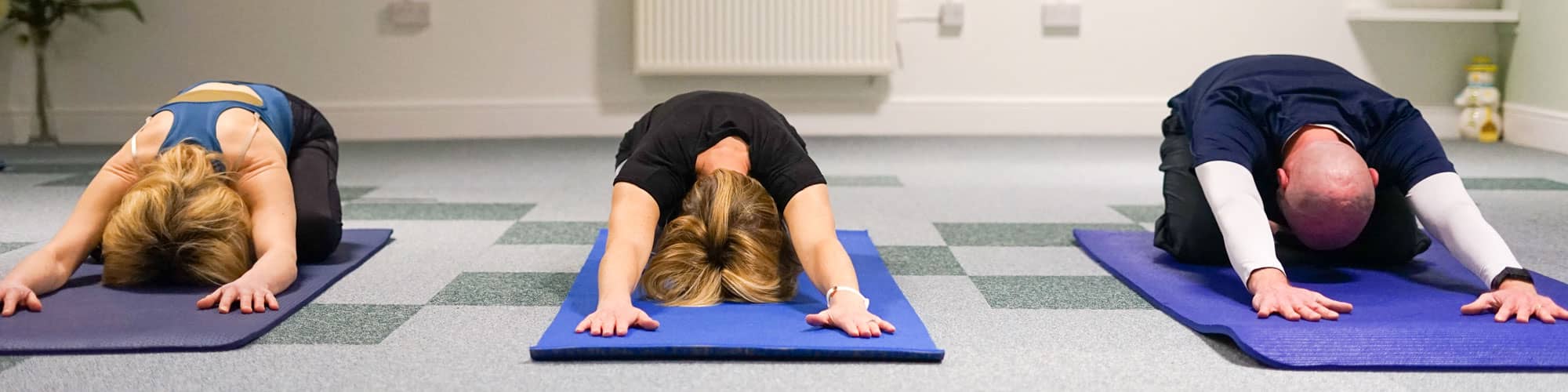 Yoga class in child pose in Wrexham