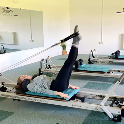 Pilates instructor using Reformer