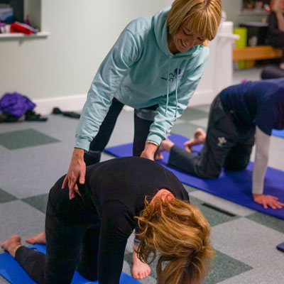 Pilates instructor helping lady